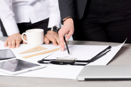 close up businesswoman s hand holding pencil paper clipboard desk 1