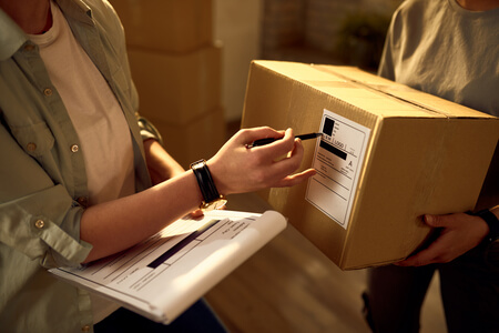 two delivery women cooperating while checking data packages office 1